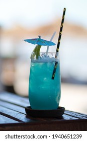 Blue Hawaiian Drink In A Glass By The Beach.