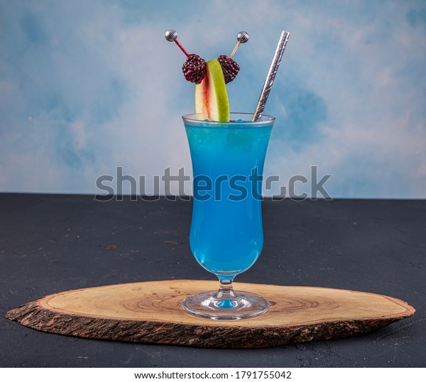 Blue Hawaiian Lagoon Cocktail\
on a dark concrete background. Iced blue cosmopolitan cocktail.\
Blue curacao liqueur. Iced blue cosmopolitan. Summer\
drink.
