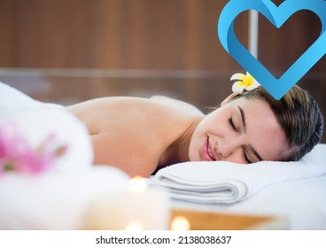 Blue Heart Icon Against Caucasian Young Woman Lying In A Massage Parlor. Beauty Spa Concept