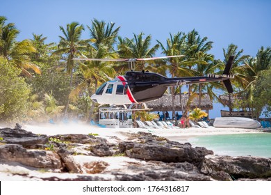 Blue Helicopter Landing On Tropical Caribbean Beach During Private Excursion In Dominican Republic To Saona Island