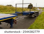 Blue HGV lorry truck extendable flatbed trailer being extended at roadside for wind turbine route test