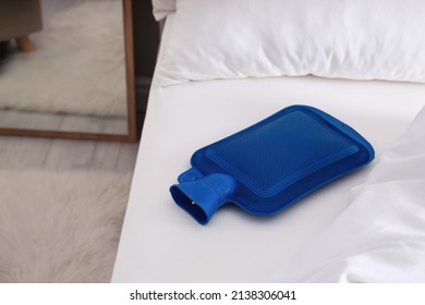 Blue Hot Water Bottle On White Bed Indoors