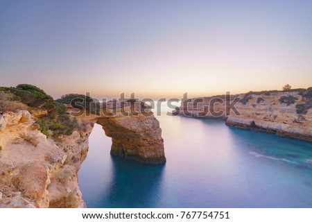A blue hour long exposure shot shortly after sunset at a rock arch at the Algarve coast in Portugal. Praia da Albandeira.