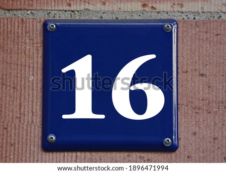 A blue house number plaque, showing the number sixteen (16) 