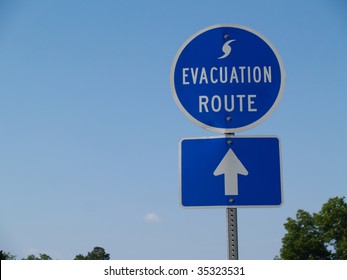 Blue hurricane evacuation route sign along a highway.