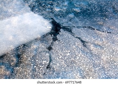 Blue ice of Baikal lake in Siberia, cracks and hummocks, shards of ice and crystal. The natural background.