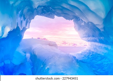 blue ice cave covered with snow and flooded with light