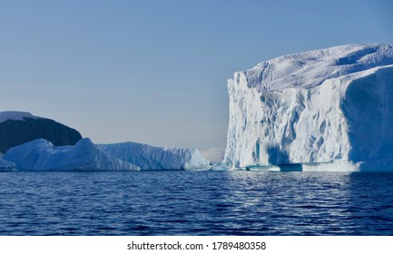 Blue Iceberg In Antarctic Ocean, Blue Sky And Sun, Melting Ice, Antarctica