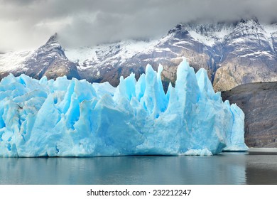 Blue icebergs and snowy mountains at Grey Glacier in Torres del Paine National Park, Patagonia, Chile 