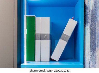 Blue Illuminated Book Shelf. There Are Three Books With Numbers 