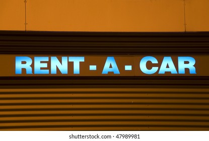 Blue Illuminated Rental Car Sign With Orange Background