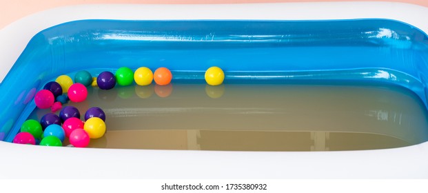 The Blue Inflatable Pool Inside Has Many Colored Balls.