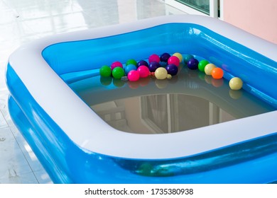 The Blue Inflatable Pool Inside Has Many Colored Balls.