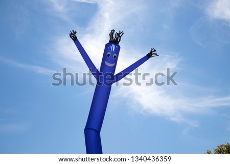 The Blue inflatable tube man with blue sky background. Air power dancer guy.