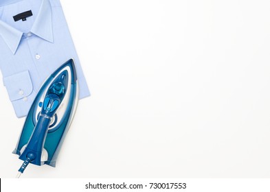 Blue iron and shirt on ironing board top view. iron board clothes ironing shirt household appliance electric concept