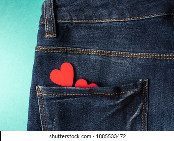 Blue jeans and in the back pocket of jeans lies two red hearts on a green background - Powered by Shutterstock