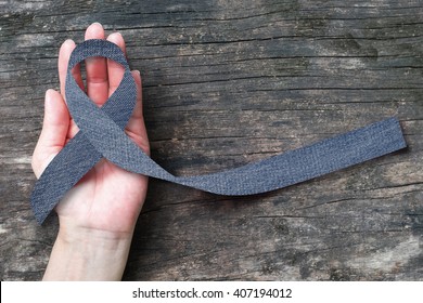 Blue Jeans Denim Ribbon (isolated With Clipping Path) On Helping Hand Support And Aged Wood For Genetic Disorder Awareness And Children's Rare Disease Illness 