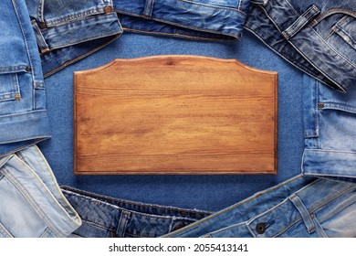 Blue Jeans Denim And Sign Wood Name Plate. Jeans Heap With Wooden Nameplate Background Texture