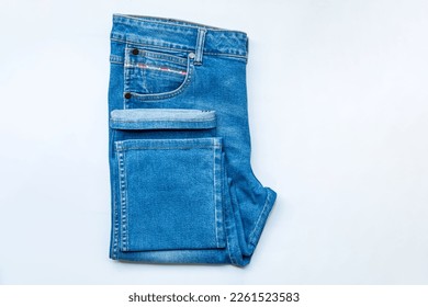 Blue jeans front of pocket and leg trouser jeans, stack of denim pants, composition, denim texture. top view on white background. - Shutterstock ID 2261523583