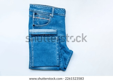 Blue jeans front of pocket and leg trouser jeans, stack of denim pants, composition, denim texture. top view on white background.