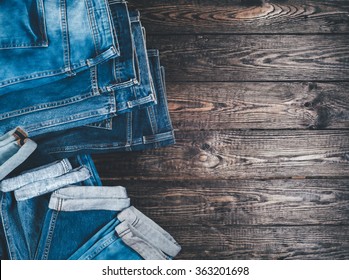 Blue jeans on a brown wooden background.Frayed jeans on a rough wood surface.
