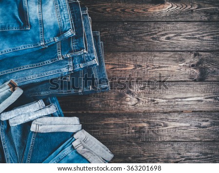 Blue jeans on a brown wooden background.Frayed jeans on a rough wood surface.