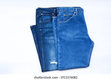 blue jeans in a row, stack of denim pants, composition, denim texture on white background.