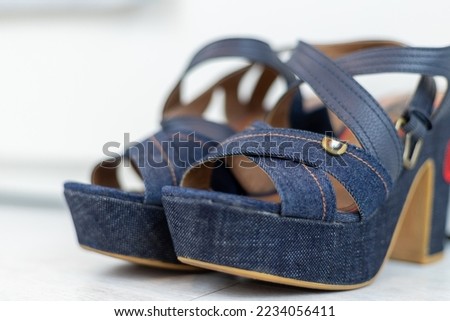 Blue Jeans shoes with a high heel in front of a white closet. High quality photo
