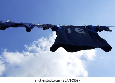 Blue Jersey Number 16 Hanging On Clothesline, Bottom-up View, Horizontal