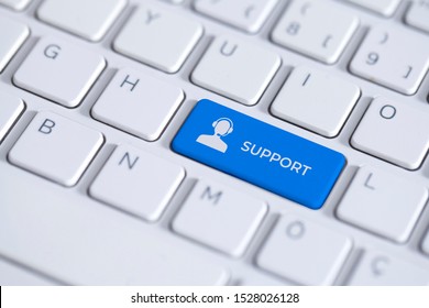 Blue key with support icon on white laptop keyboard. The support button has a text and symbol on keyboard