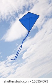 Blue Kite Flying In A Beautiful Sky Clouds