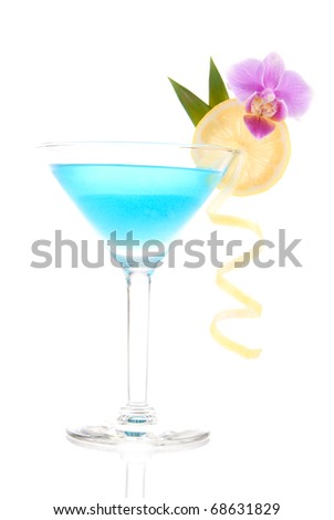 Blue lagoon cocktail with vodka, triple sec, white cranberry juice, lime, lemon wheel, pineapple leaf and orchid in martini glass isolated on a white background