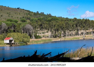 Blue lake with a beautiful small pier in the mountain area at Wiesenhof Dam, Klapmuts, Stellenbosch, South Africa.