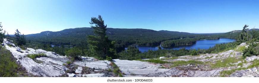 Blue Lake Behind Trees, Taken Somewhere Along The La Cloche Trail In The Killarney National Park, Ontario, Canada