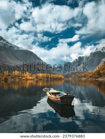 Blue Lake Mountains with yellow Trees and boat floating on a lake