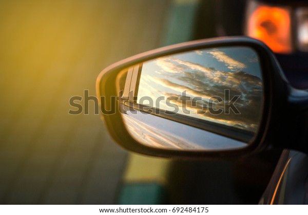 Blue landscape\
sunset reflect in mirror of\
car