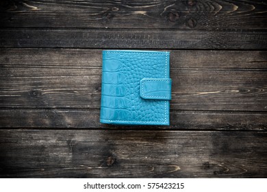 Blue leather wallet on wooden background top view