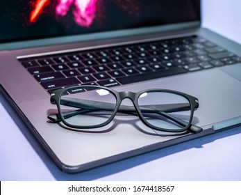 Blue Light Blocking Glasses On The Laptop. Black Frame Glasses For Filtering Blue Light From The Computer. Prevent Computer Vision Syndrome. Eye Protection From PC Screen