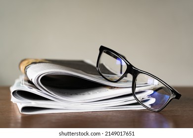 Blue Light Blocking Glasses On Stack Of Newspapers