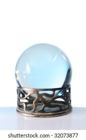 Blue Light In A Crystal Ball In Stand Against A White Background