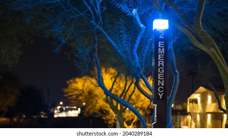 Blue Light Emergency Phone In A College Campus In Lake Havasu City, Arizona. Captured At Night With The Surrounding City Lights In Bokeh In The Background.