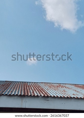 blue light sky with some cloud in front of old roof rop
