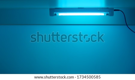 Blue light from ultraviolet lamp. UV lamp sterilization of air and surfaces. Coronavirus epidemic prevention concept. Copy space
