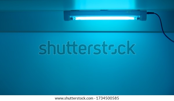Blue light from ultraviolet lamp. UV lamp\
sterilization of air and surfaces. Coronavirus epidemic prevention\
concept. Copy space