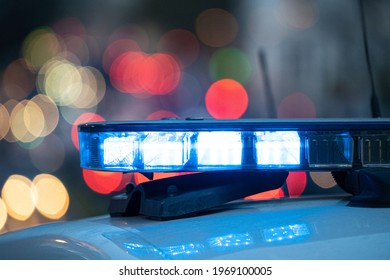 Luces azules en el techo de un auto de la policía con el fondo fuera de foco y luces con efecto bokeh	

