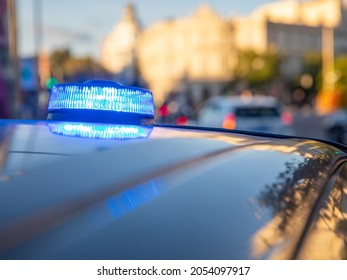 blue lights on the roof of a police car with the background out of focus and lights with bokeh effect