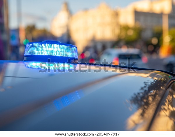 blue lights on the roof of a\
police car with the background out of focus and lights with bokeh\
effect