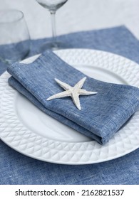 Blue Linen Napkin On A Plate Decorated With A Sea Star.