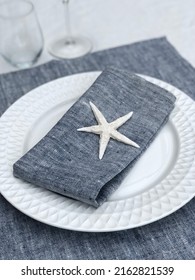 Blue Linen Napkin On A Plate Decorated With A Sea Star.