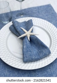 Blue Linen Napkin On A Plate Decorated With A Sea Star.